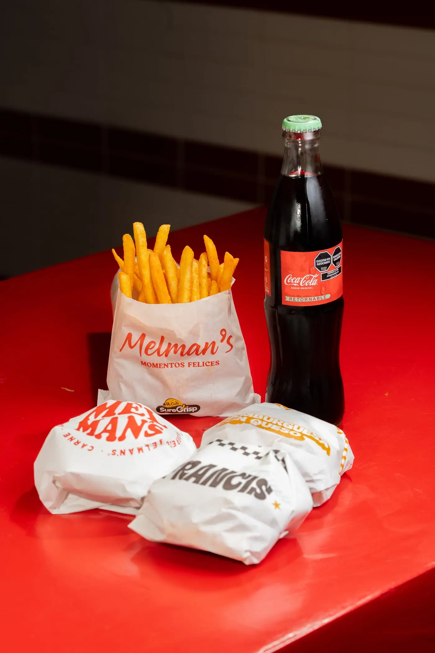 Combo de Melman’s: papas fritas, hamburguesas envueltas y Coca-Cola de vidrio