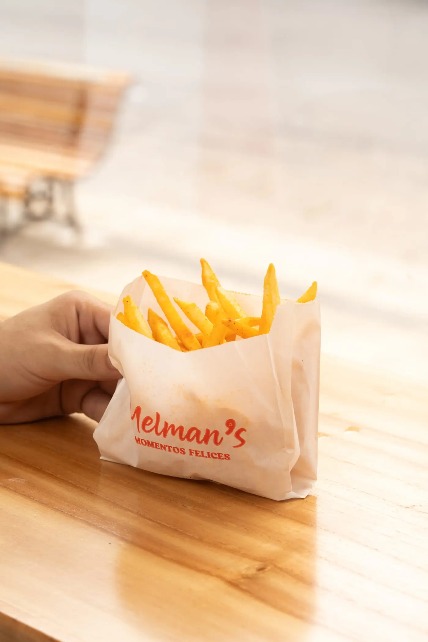 Papas fritas de Melman’s sobre un banco al sol