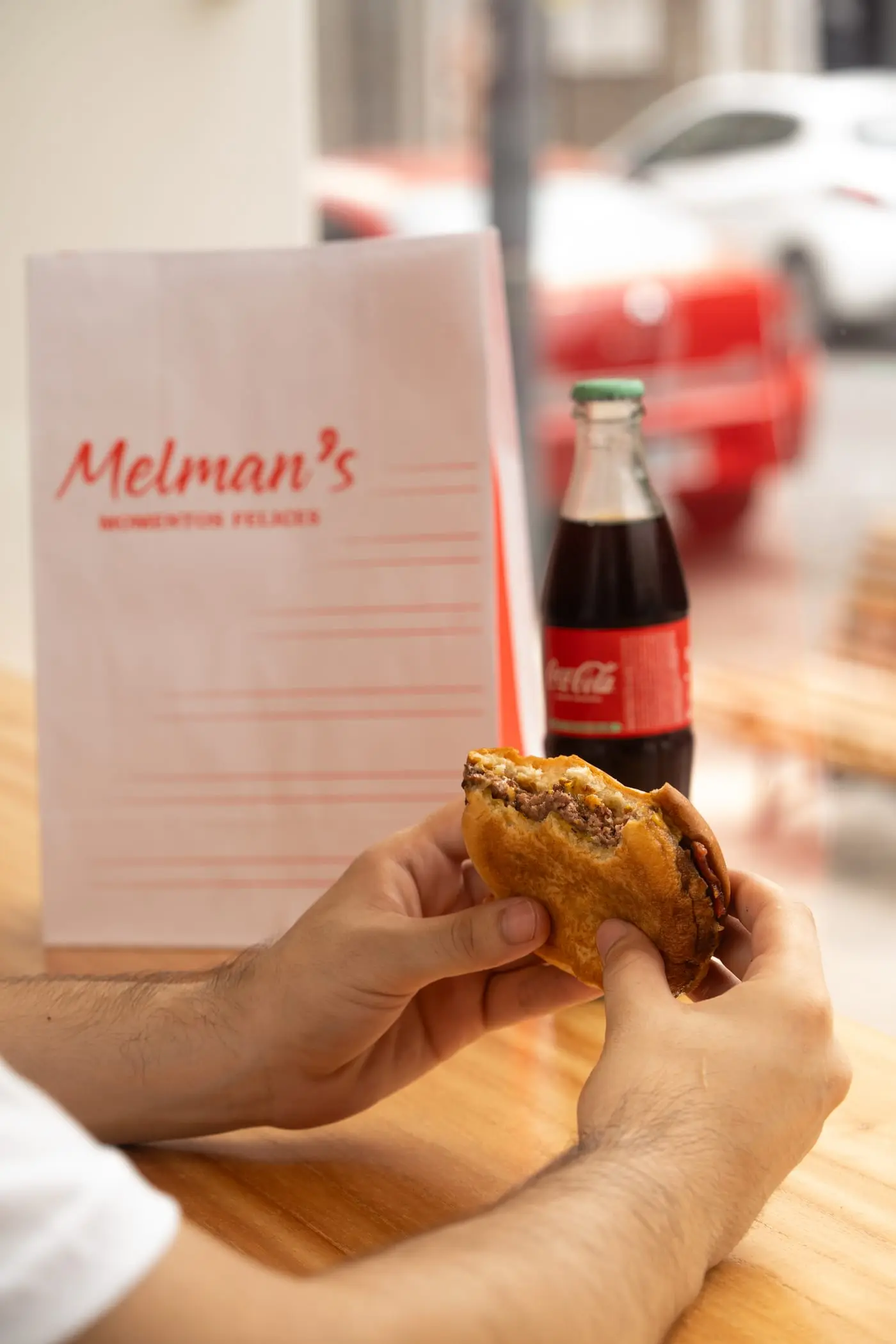 Hamburguesa y Coca-Cola de vidrio junto a la carta de Melman’s